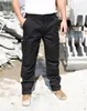 A person wearing black work pants stands in a construction site. Anteprima dell’immagine prodotto