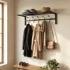A coat rack with coats, scarves, hats, and a bag hanging on it, with a bench and shoes below. Produktbild-Vorschau
