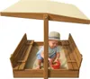 A baby playing in a wooden sandbox with a canopy. Podgląd zdjęcia produktu