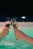 Two people toasting champagne glasses in a hot tub. Produktbild-Vorschau