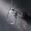 A close-up shot of a modern chrome shower faucet mounted on a textured gray wall. Produktbild-Vorschau