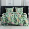 A neatly made bed with a tropical leaf-patterned duvet and pillows. Náhľad obrázku produktu