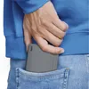 A person's hand is placing a gray portable charger into the back pocket of their blue jeans. Anteprima dell’immagine prodotto