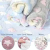 Rolled up blankets with cloud and star patterns, with close-up insets showing texture and a small animal on a blanket. Produktbild-Vorschau