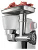 Close-up of a meat grinder attachment on a kitchen machine, with raw meat in the tray. Anteprima dell’immagine prodotto
