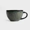 A dark green ceramic mug is shown against a white background. Podgląd zdjęcia produktu