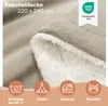 A close-up of a beige sherpa blanket, showing its texture and softness. Four circular icons at the bottom illustrate different uses: washing, camping, home, and picnic. Produktbild-Vorschau