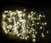 A tangled pile of white LED string lights with green wire on a dark background. Produktbild-Vorschau