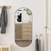 A hallway with a mirror reflecting a cabinet and artwork, a coat hanging on a rack, and an umbrella stand. Náhľad obrázku produktu
