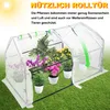 A greenhouse with plants inside, set on a grassy lawn. Voir les images du produit