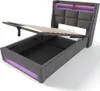 A bed frame with the storage compartment open and the mattress support raised, showing the storage space underneath. LED lighting is visible along the headboard and base. Voir les images du produit
