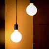 Two hanging light bulbs against a warm, textured wall. Anteprima dell’immagine prodotto