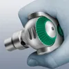 A hand wearing a light blue glove is holding a tool. Produktbild-Vorschau