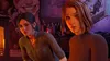 Two young women are shown in a dimly lit, possibly a bar or lounge, setting. The woman on the left has dark hair pulled back and is wearing a green shirt. The woman on the right has short brown hair and is wearing a brown turtleneck. Behind them, there's a Náhled obrázku produktu