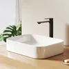 A modern bathroom sink with a black faucet on a wooden countertop. Voir les images du produit