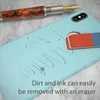 A light blue phone case with ink marks and an eraser next to a fountain pen on a marble surface. Produktbild-Vorschau