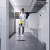 A woman is cleaning a public restroom with a squeegee. Náhled obrázku produktu