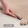 A hand is shown pressing down on a beige rug, demonstrating its softness and thickness. A close-up inset shows the rug's pile height. Náhled obrázku produktu