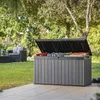 A garden storage box filled with cushions is placed on a patio in a garden setting. Voir les images du produit