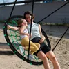 A mother and daughter are laughing while sitting on a large nest swing in a sandy outdoor area. Voir les images du produit