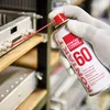A gloved hand sprays a cleaning product onto electronic equipment on a shelf. Anteprima dell’immagine prodotto