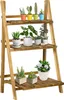A wooden plant stand with various potted plants on its shelves. Produktbild-Vorschau