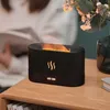A black humidifier with a flame effect sits on a wooden table next to a vase of flowers. Voir les images du produit