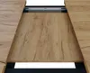 A close-up view of an extendable dining table with a wood-grain finish. Produktbild-Vorschau