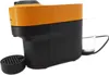 A close-up side view of a black and orange Nespresso coffee machine with a small glass next to it and a drip tray in front. Produktbild-Vorschau
