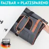 A person is folding a pet carrier bag and placing it into a drawer, demonstrating its space-saving feature. Produktbild-Vorschau