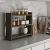 A kitchen counter with a spice rack, coffee maker, and other kitchen items. Anteprima dell’immagine prodotto