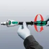 Hands wearing white gloves are holding a tool with a red circular arrow indicating rotation. Produktbild-Vorschau