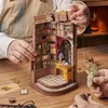 Hands assembling a miniature wooden book nook with bookshelves, a desk, and a chair. Náhled obrázku produktu