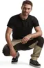 A man is crouching down, wearing work pants and a t-shirt. Produktbild-Vorschau