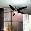 A modern ceiling fan with lights mounted on a textured ceiling above a decorative screen and a plant. Produktbild-Vorschau