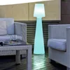 An outdoor patio setting with furniture and a glowing floor lamp. Anteprima dell’immagine prodotto