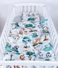 A baby blanket and pillow set with a jungle animal theme laid out in a white crib. Produktbild-Vorschau