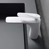 A close-up shot of a modern white faucet mounted on a gray surface. Anteprima dell’immagine prodotto