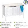 A white storage bench with a beige cushion, a blue towel draped over the side, and marketing text and a logo. Podgląd zdjęcia produktu