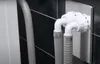 A close-up view of a plumbing fixture with two flexible hoses connected to a wall-mounted unit. Anteprima dell’immagine prodotto