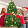 A family is decorating a Christmas tree together. Anteprima dell’immagine prodotto