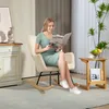 A woman is sitting in a rocking chair reading a magazine. Produktbild-Vorschau