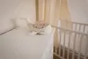 A white whale-shaped night light sits on a white dresser next to a white crib. A beige curtain hangs in the background. Anteprima dell’immagine prodotto