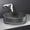 A modern bathroom sink setup with a glass basin and a wall-mounted faucet. Anteprima dell’immagine prodotto