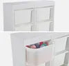 A white storage unit for children with multiple compartments, some of which contain white plastic bins. The bottom image shows one bin pulled out, filled with colorful balls. Produktbild-Vorschau