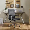 A black office chair is placed in front of a desk in a home office setting. Produktbild-Vorschau