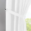 A close-up view of a white curtain with a tie-back. Produktbild-Vorschau