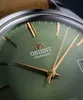 Close-up of a watch face with green dial and gold hands. Podgląd zdjęcia produktu