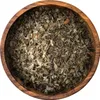 A close-up view of dried herbs in a wooden bowl. Produktbild-Vorschau