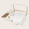 A collection of disassembled parts for a baby bed or playpen, laid out on a neutral background. Produktbild-Vorschau